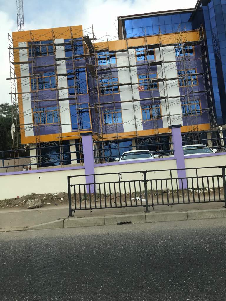 Building facade under construction with Alucobond composite panels being installed in Accra