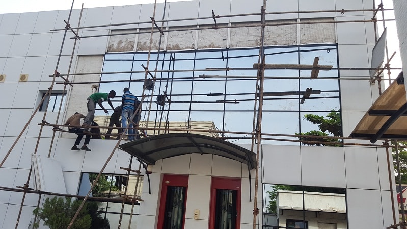 Alucobond Ghana construction workers installing composite panel cladding on a building